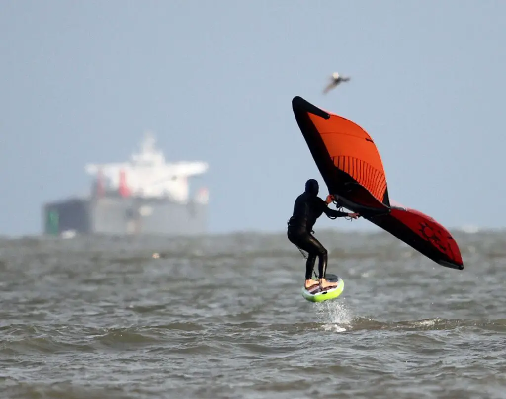 Upper left: Cliff Hiner of Denver, Colo., rides a foil board while wing surfing. Staff photo by Dan Parker