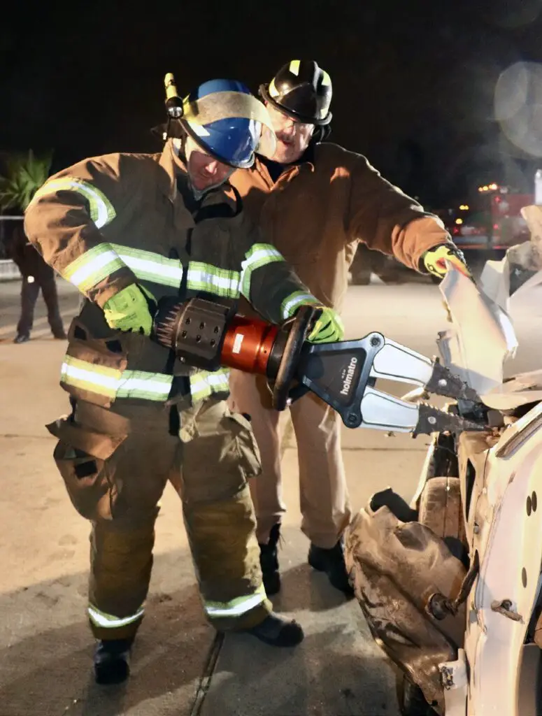 Middle right: Wren, left, trains with the jaws of life, a hydraulic tool used for prying apart auto wreckage when accident victims are trapped inside. Walters is at right.