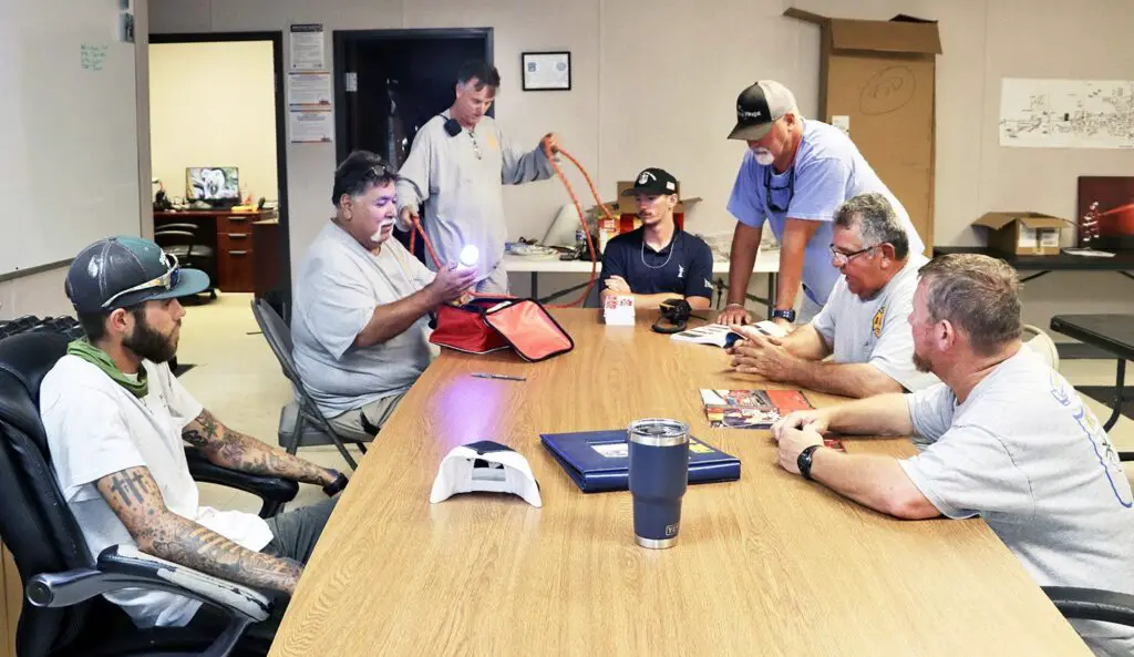 Members of the Port Aransas Volunteer Fire Department confer around a table in their temporary quarters on Avenue C, just east of Alister Street, on a recent day. Clockwise from left are Toby Smith, Adam Maldonado, Vinton James, Noah Swindle, Nathan Kelley, Pete Arzola and Nathan Arnold. The fire department has been operating out of temporary quarters since Hurricane Harvey hit Port Aransas in 2017. The city is working on plans to build a new fire station. Staff photo by Lee Harrison
